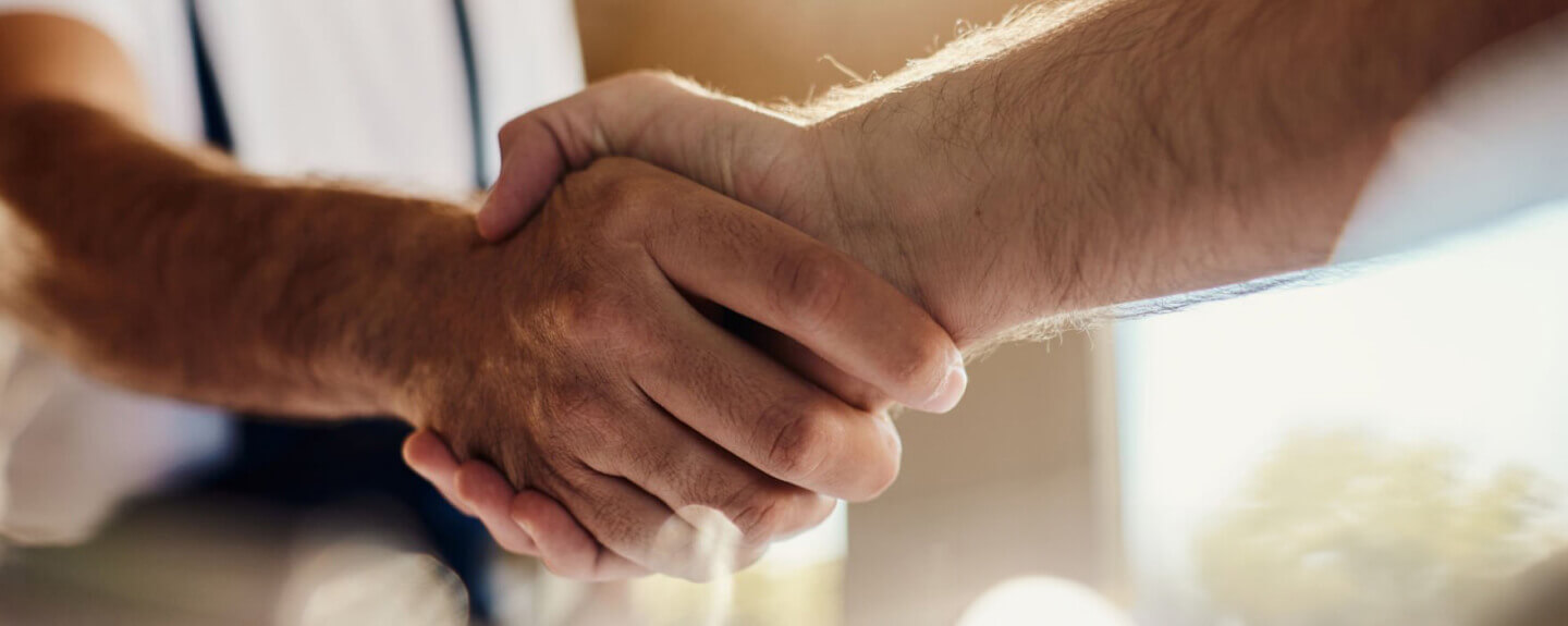 close up of 2 men shaking hands