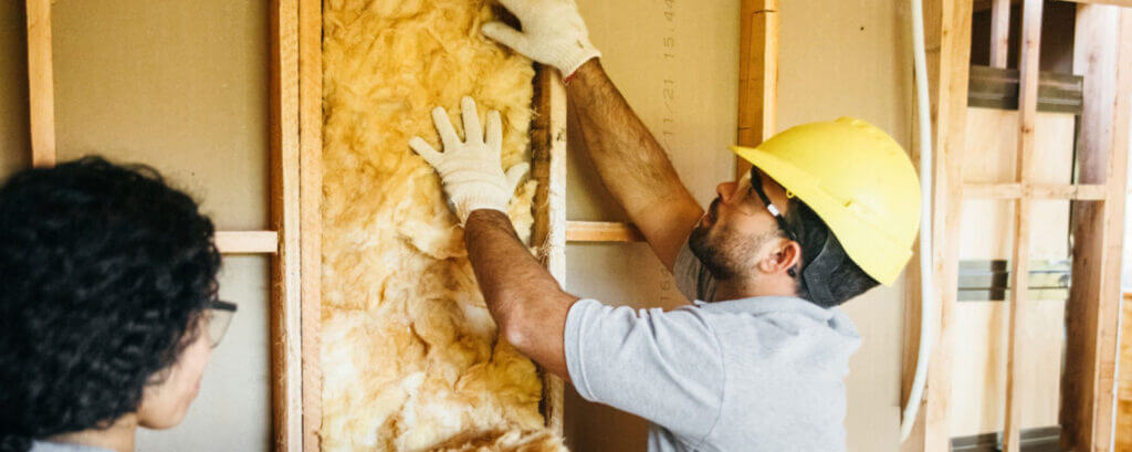 installer installing fiberglass insulation