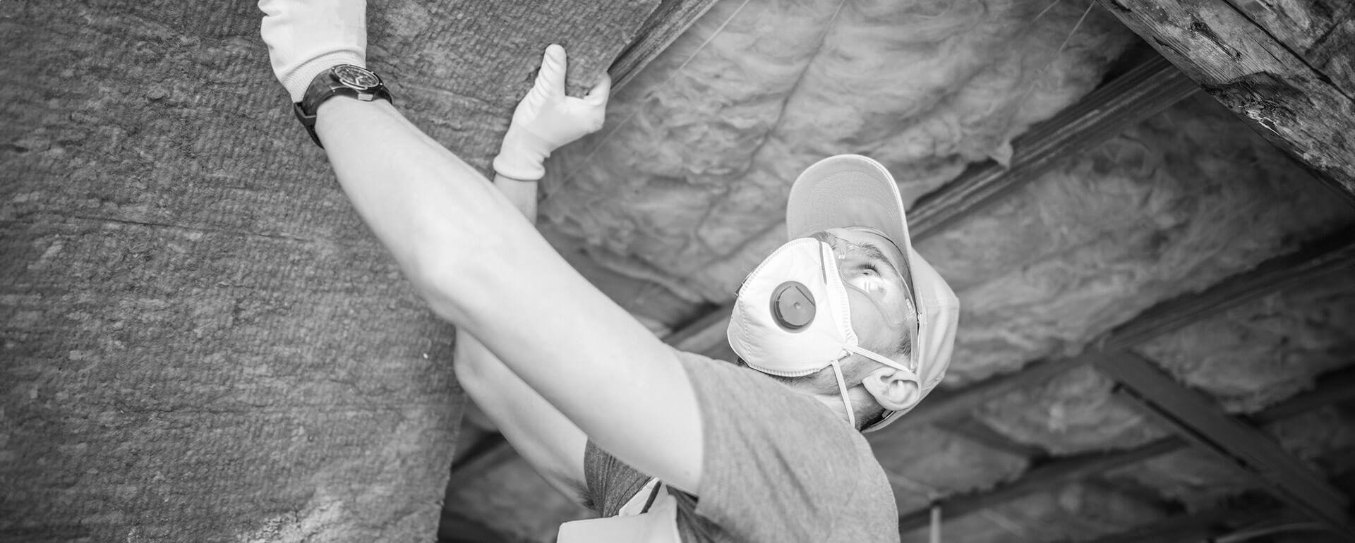 person wearing protective gear to install insulation