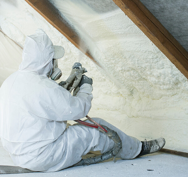 installer spraying foam insulation